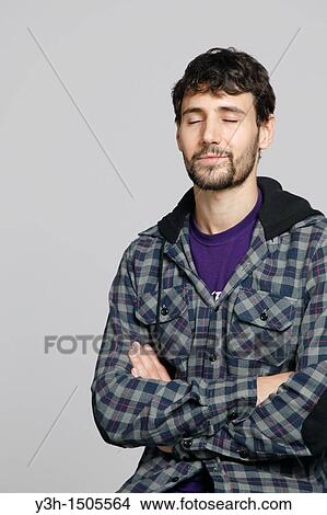 Studio shot of young man, arms crossed View Large Photo Image Picture - Studio shot of young man, arms crossed. Fotosearch