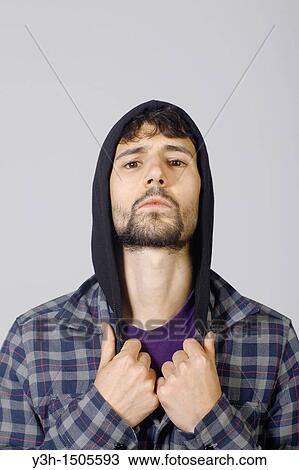 Stock Image - Studio shot of young man, hooded jacket. Fotosearch