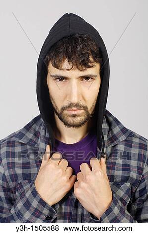 Stock Photo - Studio shot of young man, hooded jacket. Fotosearch