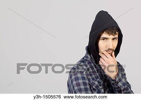 Stock Photograph - Studio shot of young man, hooded jacket. Fotosearch