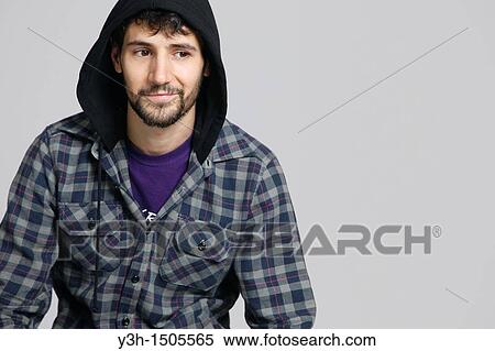 Stock Photography - Studio shot of young man, hooded jacket. Fotosearch