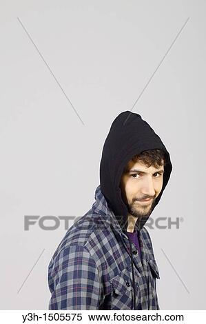 Stock Photography - Studio shot of young man, hooded jacket. Fotosearch