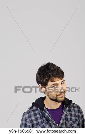 Stock Image - Studio shot of young man, looking at camera. Fotosearch