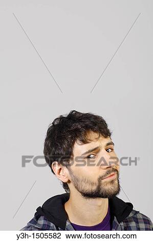 Stock Image - Studio shot of young man, looking at camera. Fotosearch