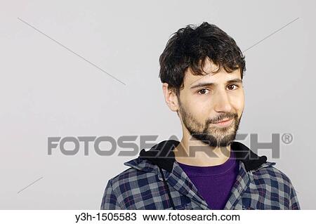 Stock Image - Studio shot of young man, looking at camera. Fotosearch