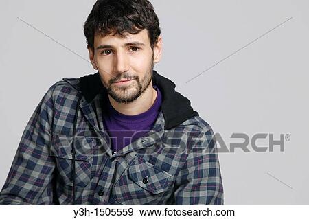 Stock Photo - Studio shot of young man, looking at camera. Fotosearch