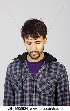 Studio shot of young man, looking down View Large Photo Image Picture - Studio shot of young man, looking down. Fotosearch