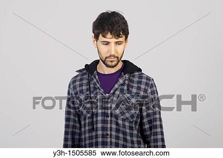 Stock Photography - Studio shot of young man, looking down. Fotosearch