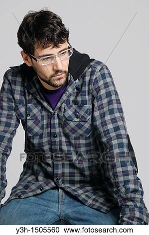 Stock Image - Studio shot of young man, thoughtful. Fotosearch