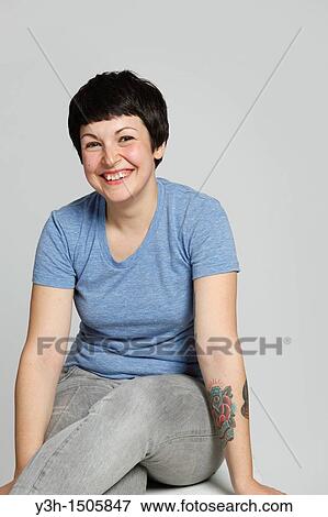 Studio shot of young tattooed woman View Large Photo Image Stock Photo - Studio shot of young tattooed woman. Fotosearch