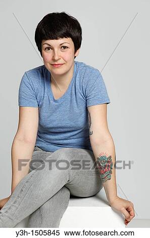 Studio shot of young tattooed woman View Large Photo Image Stock Photography - Studio shot of young tattooed woman. Fotosearch