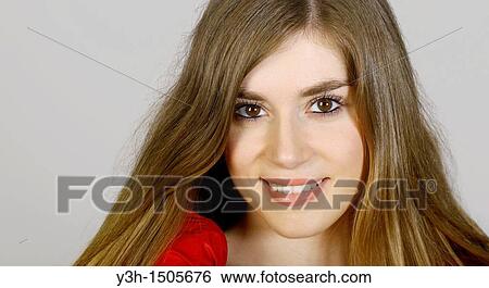 Stock Photograph - Studio shot of young woman, smiling. Fotosearch