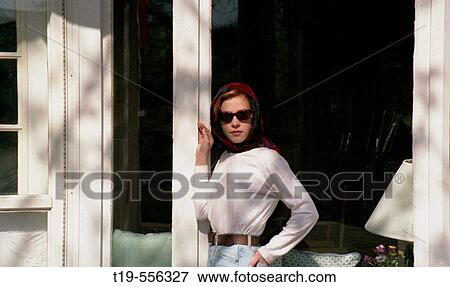 Stock Photo - Stylish young woman stopping to pose while window shopping. Fotosearch