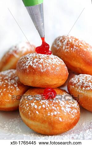 Sufganiyah Sufganyot a traditional Jewish Doughnut eaten during Hanukkah with red jam and sugar powder View Large Photo Image Stock Photography - Sufganiyah Sufganyot a traditional Jewish Doughnut eaten during Hanukkah with red jam and sugar powder. Fotosearch