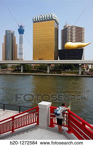 Picture - Sumidagawa river, Asahi Beer Tower and Tokyo Sky Tree under construction, Asakusa, Tokyo, Japan.. Fotosearch