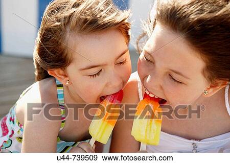 Stock Photo - Summer 2 girls having fun with an Ice cream. Fotosearch