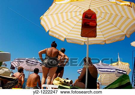Sunbathers sitting on sun beads looking at the sea Piran, Slovenia View Large Photo Image Stock Photo - Sunbathers sitting on sun beads looking at the sea Piran, Slovenia. Fotosearch