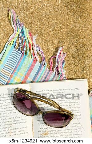 Sunglasses and novel on a beach towel View Large Photo Image Stock Image - Sunglasses and novel on a beach towel. Fotosearch