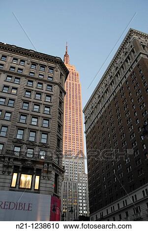 Stock Image - Sunlit Empire State Building in the early evening. Midtown West Manhattan, New York, New York. USA.. Fotosearch