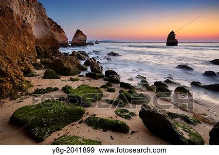 Stock Photo - Sunrise at Algarve rocky coast near Lagos, Algarve, Portugal.. Fotosearch