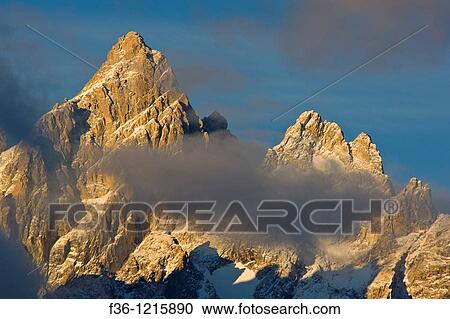 Sunrise light and clouds on the summit peak of the Grand Teton mountain, Grand Teton National Park, Wyoming View Large Photo Image Stock Image - Sunrise light and clouds on the summit peak of the Grand Teton mountain, Grand Teton National Park, Wyoming. Fotosearch