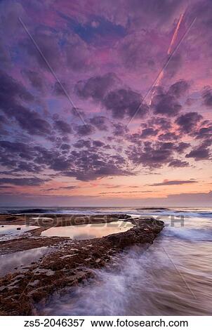 Stock Photo - Sunrise with rocks and waves in a cape Cabo Huertas in Alicante, Costa Blanca, Comunidad Valenciana, Spain, Europe.. Fotosearch
