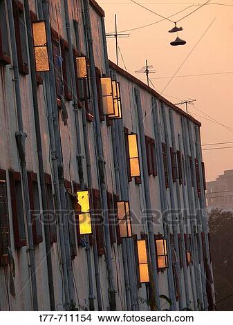 Sunset light is reflected on glass finished window shutters of a residential building at Vadgaon Budruk Pune, Maharashtra, India View Large Photo Image Picture - Sunset light is reflected on glass finished window shutters of a residential building at Vadgaon Budruk Pune, Maharashtra, India. Fotosearch