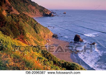 Stock Photo - Sunset light on coastal cliffs over beach near Crescent City, California.. Fotosearch