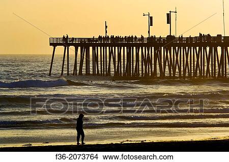 Sunset light over the pier and ocean waves at Pismo Beach, San Luis Obispo County coast, California. View Large Photo Image Picture - Sunset light over the pier and ocean waves at Pismo Beach, San Luis Obispo County coast, California.. Fotosearch