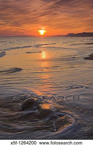 Sunset on the beach at Burton Bradstock looking towards Lyme Regis in the Distance Dorset View Large Photo Image Stock Image - Sunset on the beach at Burton Bradstock looking towards Lyme Regis in the Distance Dorset. Fotosearch