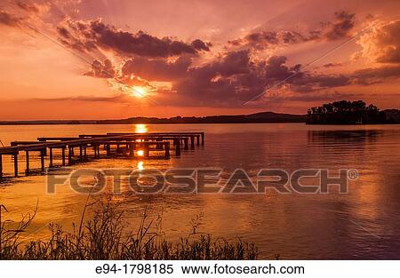 Stock Photography - Sunset over a lake with a small boat dock silhouetted in the foreground, Lake Guntersville State Park, Alabama, USA.. Fotosearch