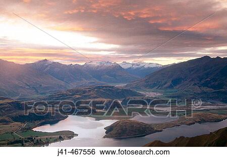 Sunset over Lake Wanaka. Mt. Aspiring in distance from Mt. Roy. Central Otago. New Zealand. View Large Photo Image Stock Photograph - Sunset over Lake Wanaka. Mt. Aspiring in distance from Mt. Roy. Central Otago. New Zealand.. Fotosearch