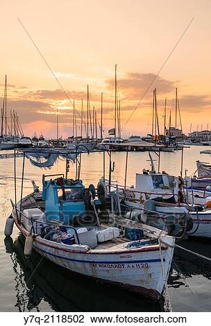 Sunset over moored fishing boats in Aegina Town harbour, Aegina Island, Greece. View Large Photo Image Stock Image - Sunset over moored fishing boats in Aegina Town harbour, Aegina Island, Greece.. Fotosearch