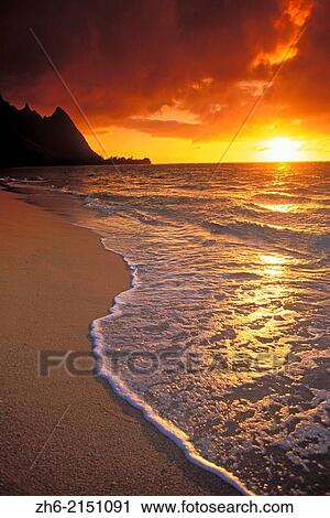 Sunset over surf, sand and peaks from Tunnels Beach, Ha'ena, Island of Kauai, Hawaii USA. View Large Photo Image Stock Image - Sunset over surf, sand and peaks from Tunnels Beach, Ha'ena, Island of Kauai, Hawaii USA.. Fotosearch