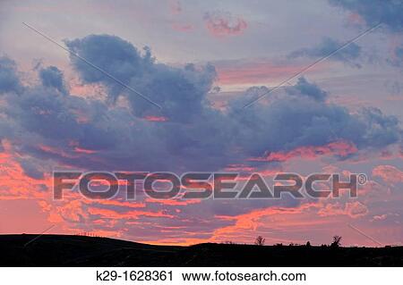 Stock Image - Sunset skies over a badlands ridge, Medora, North Dakota, USA. Fotosearch