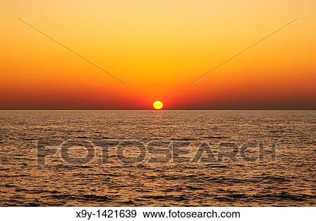 Sunset sunrise over ocean sea rising setting sun red View Large Photo Image Stock Photo - Sunset sunrise over ocean sea rising setting sun red. Fotosearch
