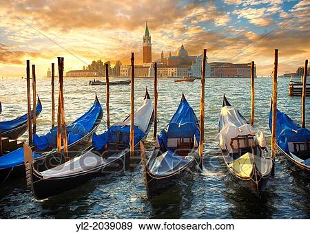Sunset view of gondolas at St Mark's Square with the island of San Giorgio Maggiore behind, with its church front designed by Andrea Palladio and begun in 1566. Venice Italy. View Large Photo Image Stock Photo - Sunset view of gondolas at St Mark's Square with the island of San Giorgio Maggiore behind, with its church front designed by Andrea Palladio and begun in 1566. Venice Italy.. Fotosearch