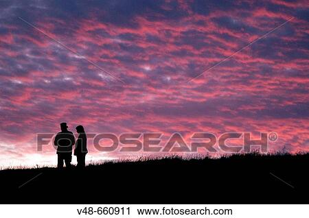 Sunset with silhouettes of two persons on the top of a dike. Netherlands (August, 2005) View Large Photo Image Stock Image - Sunset with silhouettes of two persons on the top of a dike. Netherlands (August, 2005). Fotosearch