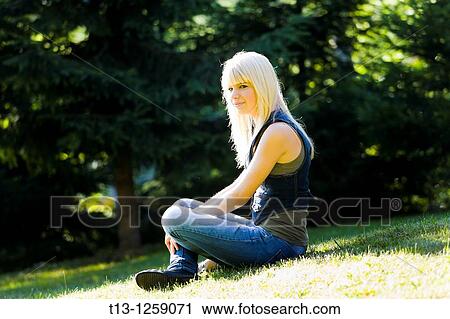 Sunshine lit young woman on a grass View Large Photo Image Stock Image - Sunshine lit young woman on a grass. Fotosearch