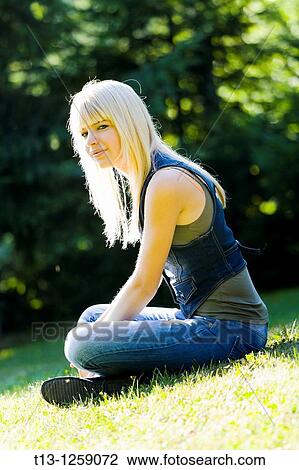 Sunshine lit young woman on a grass View Large Photo Image Stock Image - Sunshine lit young woman on a grass. Fotosearch