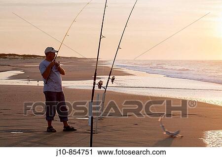 Surf-casting at sunrise, Outer Banks, Ocracoke Island, North Carolina, USA View Large Photo Image Stock Image - Surf-casting at sunrise, Outer Banks, Ocracoke Island, North Carolina, USA. Fotosearch