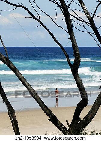 Surfer alone on the beach, Byron Bay, Australia. View Large Photo Image Picture - Surfer alone on the beach, Byron Bay, Australia.. Fotosearch