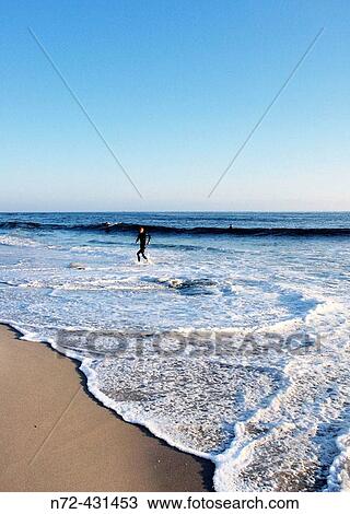 Surfer getting out of the water. Pacific Ocean. Baja California. Mexico. View Large Photo Image Stock Image - Surfer getting out of the water. Pacific Ocean. Baja California. Mexico.. Fotosearch