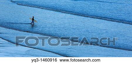 Stock Photograph - Surfer going into the sea, Ori? n, Cantabria, Spain. Fotosearch
