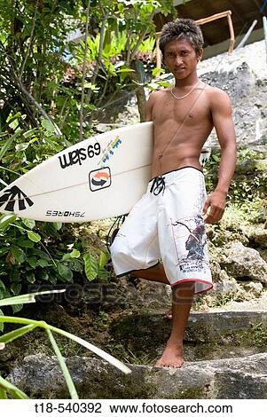 surfer holding surfboard stepping down to the beach View Large Photo Image Stock Image - surfer holding surfboard stepping down to the beach. Fotosearch