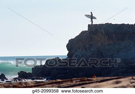 Stock Photo - Surfer on a cliff, Mauritania.. Fotosearch