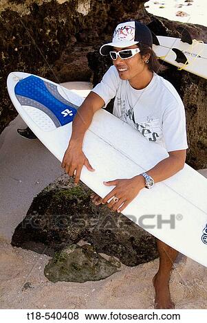 surfer sitting on rock holding surfboard View Large Photo Image Stock Photo - surfer sitting on rock holding surfboard. Fotosearch