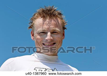 Stock Image - Surfer wearing sunblock. Fotosearch