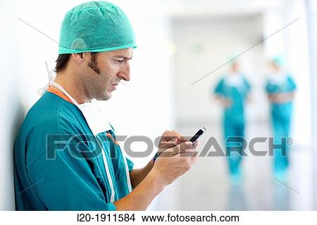 Picture - surgeon with smartphone in the operating room hallway, Onkologikoa Hospital, Oncology Institute, Case Center for prevention, diagnosis and treatment of cancer, Donostia, San Sebastian, Gipuzkoa, Basque Country, Spain. Fotosearch
