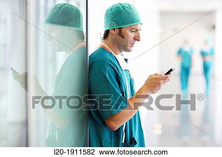 Stock Image - surgeon with smartphone in the operating room hallway, Onkologikoa Hospital, Oncology Institute, Case Center for prevention, diagnosis and treatment of cancer, Donostia, San Sebastian, Gipuzkoa, Basque Country, Spain. Fotosearch